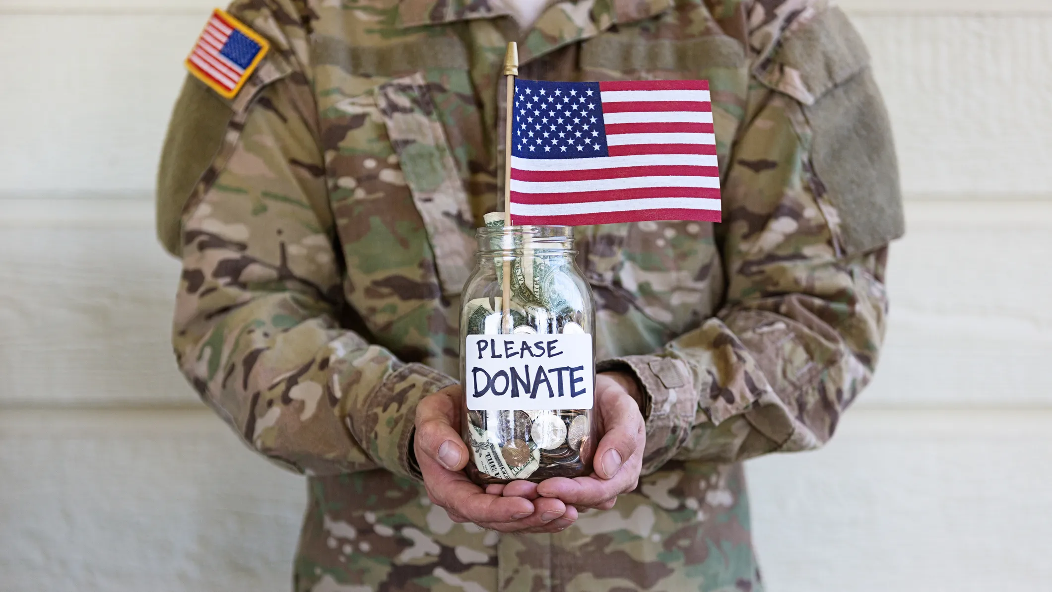 military officer holding American flag and donation jar