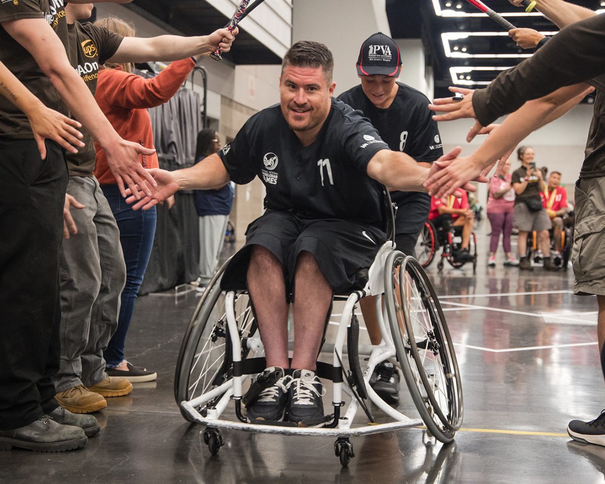 man in wheelchair getting high fives