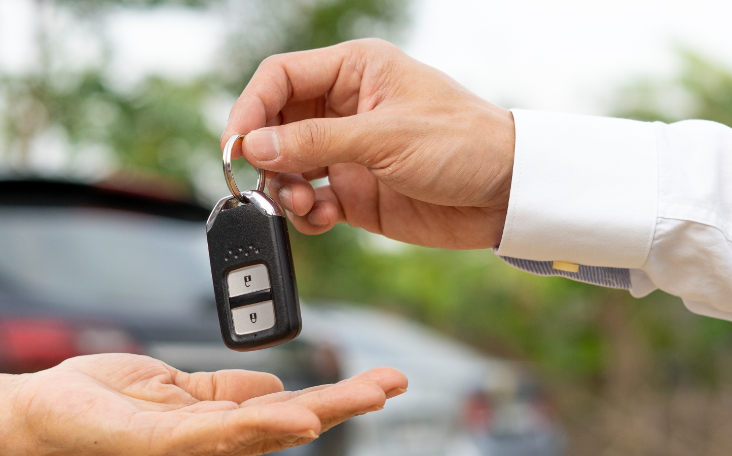 person handing car keys over to another person